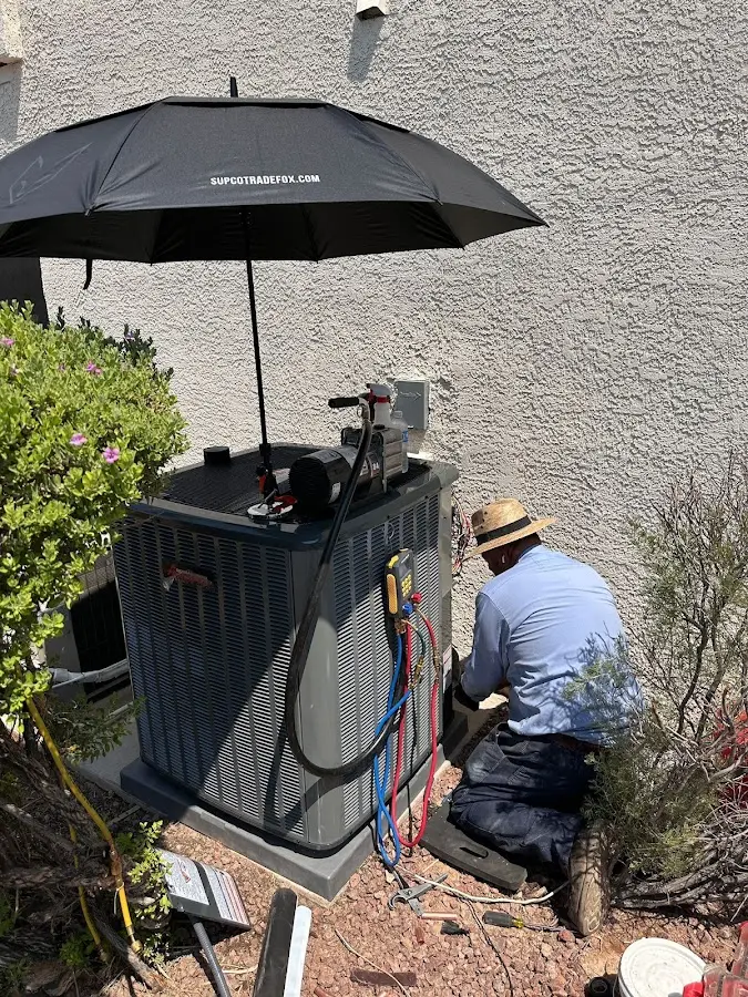 HVAC technician performing outdoor AC maintenance in Warren